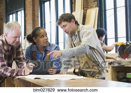 Stock Photo - Carpenters using digital tablet in workshop. Fotosearch