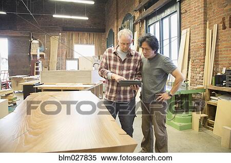Carpenters using digital tablet in workshop View Large Photo Image Stock Photography - Carpenters using digital tablet in workshop. Fotosearch