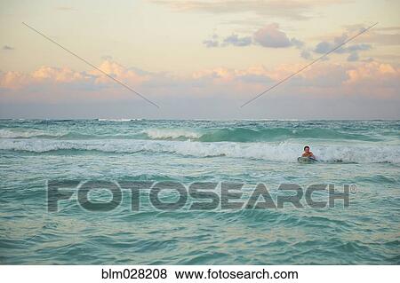 Caucasian boy playing in waves on beach View Large Photo Image Stock Photo - Caucasian boy playing in waves on beach. Fotosearch