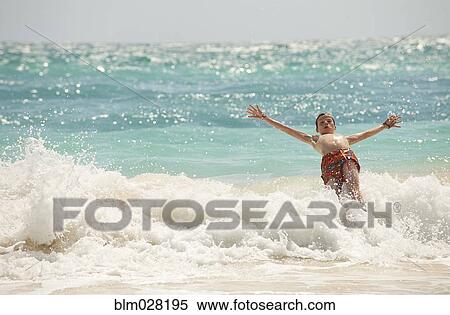 Caucasian boy playing in waves on beach View Large Photo Image Stock Photography - Caucasian boy playing in waves on beach. Fotosearch