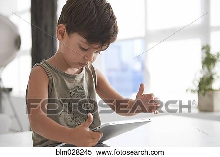 Caucasian boy using digital tablet View Large Photo Image Stock Photography - Caucasian boy using digital tablet. Fotosearch