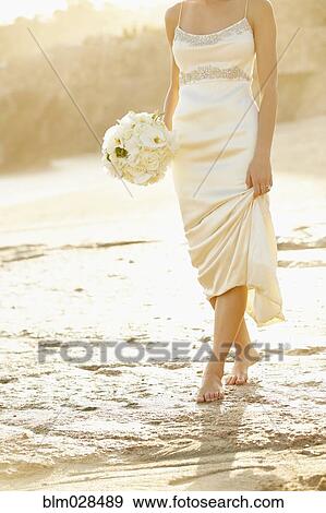 Caucasian bride holding bouquet on beach View Large Photo Image Stock Photo - Caucasian bride holding bouquet on beach. Fotosearch