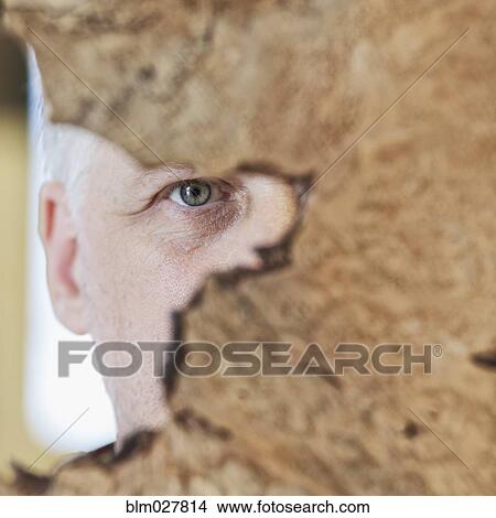 Picture - Caucasian carpenter peering from behind wood. Fotosearch