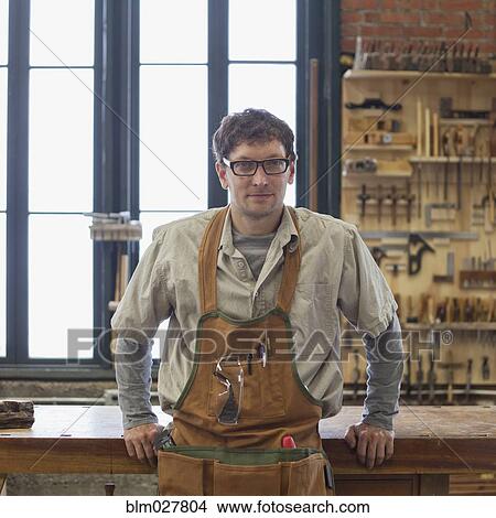 Picture - Caucasian carpenter smiling in workshop. Fotosearch