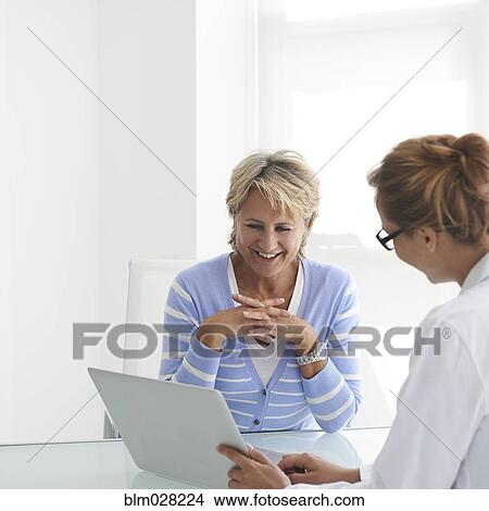 Picture - Caucasian doctor and patient talking in office. Fotosearch