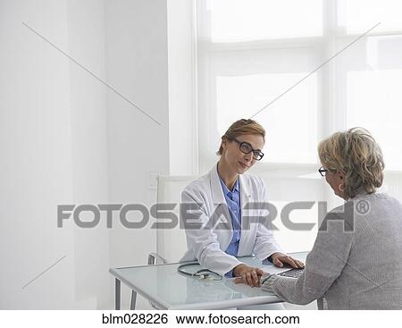 Caucasian doctor and patient talking in office View Large Photo Image Stock Photograph - Caucasian doctor and patient talking in office. Fotosearch