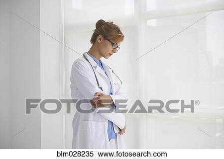Caucasian doctor standing in office View Large Photo Image Stock Photography - Caucasian doctor standing in office. Fotosearch