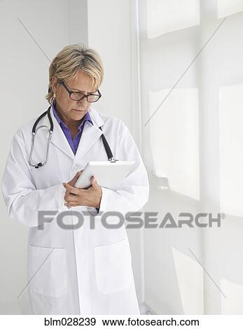 Stock Photo - Caucasian doctor using digital tablet. Fotosearch