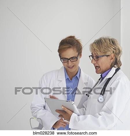 Caucasian doctors using digital tablet View Large Photo Image Stock Photo - Caucasian doctors using digital tablet. Fotosearch