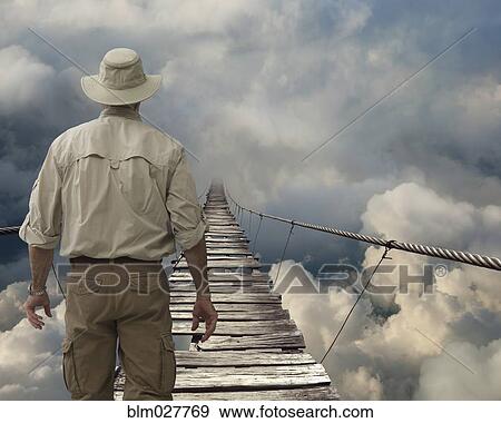 Caucasian explorer examining wooden rope bridge in clouds View Large Photo Image Stock Photo - Caucasian explorer examining wooden rope bridge in clouds. Fotosearch