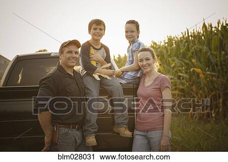 Stock Image - Caucasian family smiling on truck. Fotosearch
