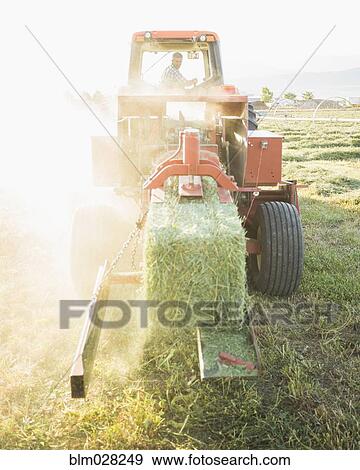 Stock Photo - Caucasian farmer driving tractor. Fotosearch