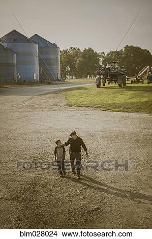 Picture - Caucasian father and son walking on farm. Fotosearch