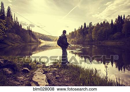 Caucasian man fishing at lakeside View Large Photo Image Stock Photo - Caucasian man fishing at lakeside. Fotosearch
