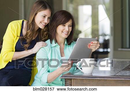 Stock Photo - Caucasian mother and daughter using digital tablet. Fotosearch
