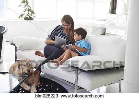 Stock Photo - Caucasian mother and son using digital tablets. Fotosearch