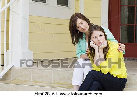 Stock Image - Caucasian mother comforting daughter outdoors. Fotosearch