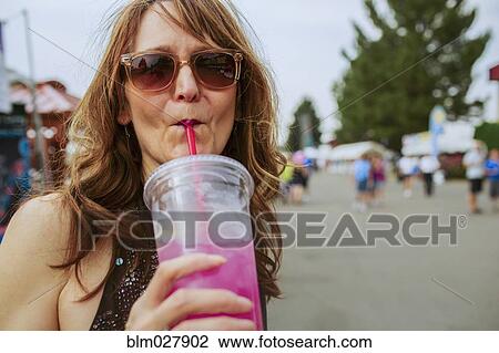 Caucasian woman drinking juice outdoors View Large Photo Image Stock Image - Caucasian woman drinking juice outdoors. Fotosearch