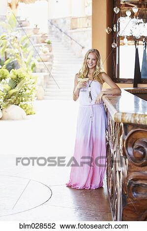Stock Image - Caucasian woman having margarita at bar. Fotosearch