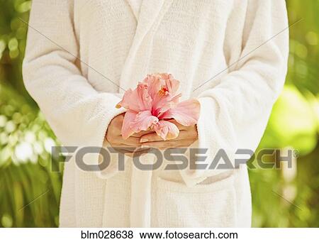 Caucasian woman in bathrobe holding flower View Large Photo Image Stock Photo - Caucasian woman in bathrobe holding flower. Fotosearch