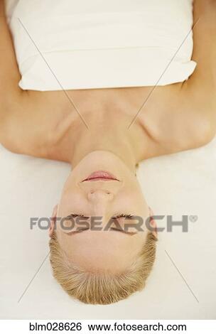 Stock Photograph - Caucasian woman laying on massage table. Fotosearch