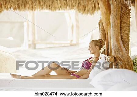 Caucasian woman relaxing in cabana View Large Photo Image Picture - Caucasian woman relaxing in cabana. Fotosearch