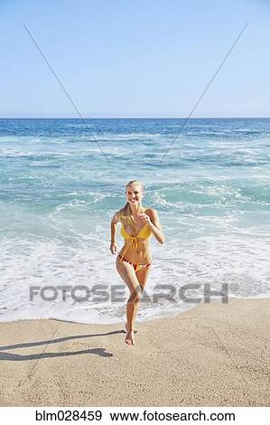 Stock Photo - Caucasian woman running on beach. Fotosearch