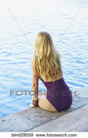 Caucasian woman sitting at the edge of swimming pool View Large Photo Image Stock Photo - Caucasian woman sitting at the edge of swimming pool. Fotosearch