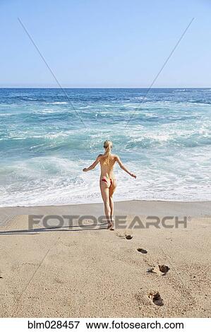 Caucasian woman walking on beach View Large Photo Image Stock Photo - Caucasian woman walking on beach. Fotosearch