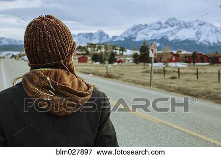 Stock Photo - Caucasian woman walking on rural road. Fotosearch