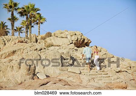 Couple climbing rocky steps View Large Photo Image Stock Photo - Couple climbing rocky steps. Fotosearch