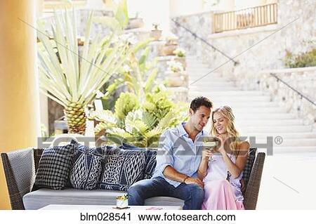 Couple having margarita together on sofa View Large Photo Image Stock Image - Couple having margarita together on sofa. Fotosearch