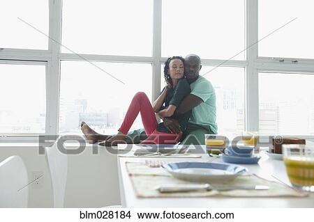 Couple hugging in window View Large Photo Image Picture - Couple hugging in window. Fotosearch