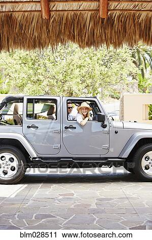 Stock Image - Couple in jeep outdoors. Fotosearch