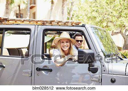 Stock Image - Couple in jeep outdoors. Fotosearch