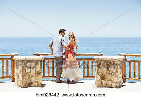 Stock Image - Couple overlooking ocean from balcony. Fotosearch