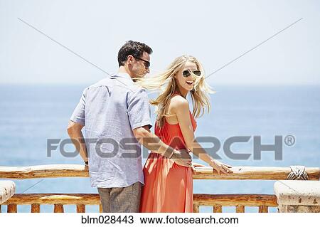 Stock Image - Couple overlooking ocean from balcony. Fotosearch