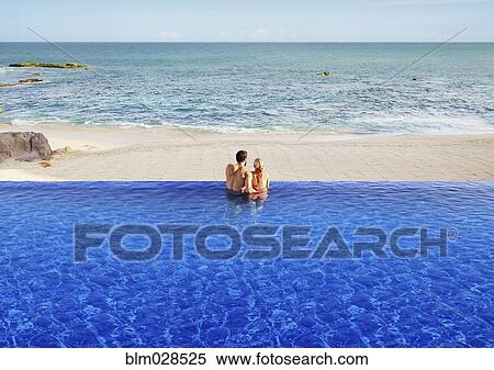 Stock Photography - Couple relaxing in infinity pool. Fotosearch