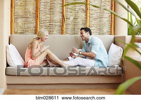 Couple relaxing together on patio sofa View Large Photo Image Stock Image - Couple relaxing together on patio sofa. Fotosearch