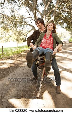 Couple riding bicycle on rural road View Large Photo Image Stock Image - Couple riding bicycle on rural road. Fotosearch