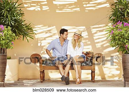 Couple sitting on patio bench View Large Photo Image Stock Photo - Couple sitting on patio bench. Fotosearch