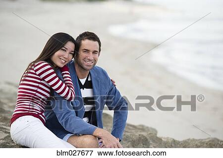Stock Photo - Couple smiling together on beach. Fotosearch