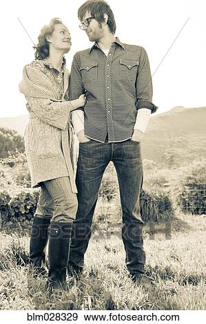 Stock Photo - Couple standing in rural field. Fotosearch