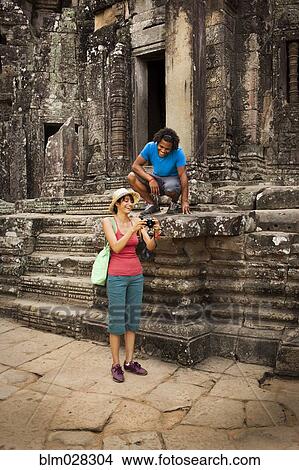 Couple visiting ancient temple, Angkor, Siem Reap, Cambodia View Large Photo Image Picture - Couple visiting ancient temple, Angkor, Siem Reap, Cambodia. Fotosearch