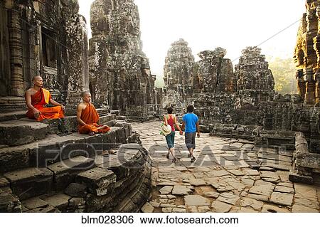Stock Photograph - Couple visiting Buddhist temple, Angkor, Siem Reap, Cambodia. Fotosearch