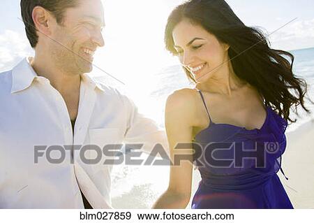 Stock Photo - Couple walking on beach. Fotosearch
