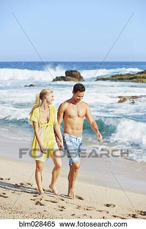 Stock Photography - Couple walking together on beach. Fotosearch
