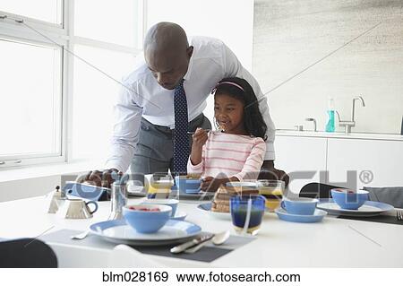 Stock Photo - Father and daughter at breakfast table. Fotosearch