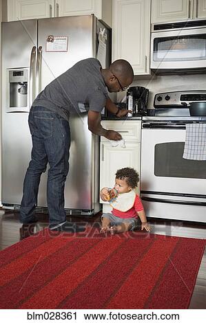 Father and toddler son in kitchen View Large Photo Image Stock Image - Father and toddler son in kitchen. Fotosearch