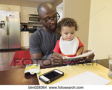 Picture - Father and toddler son sitting at table. Fotosearch